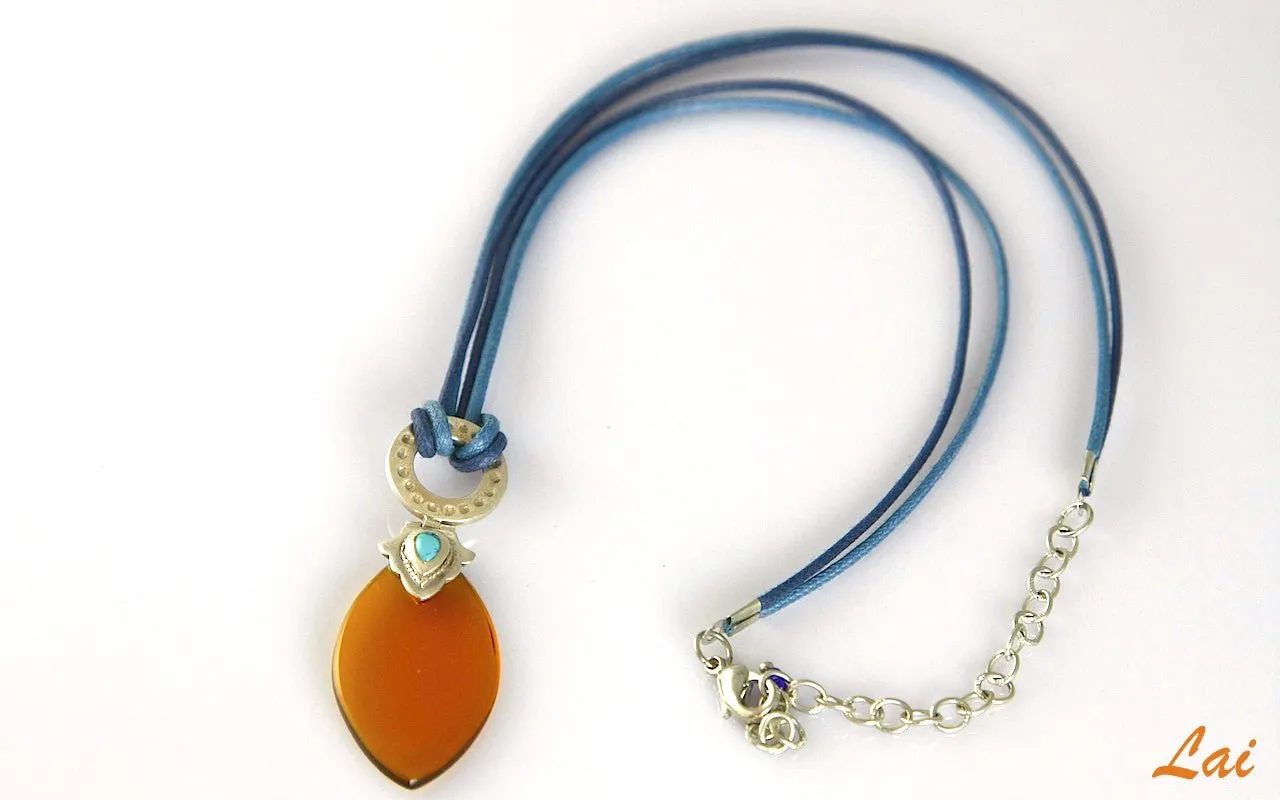 Artistic, navette shape amber colour glass pendant on contrasting blue cord